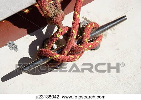 Stock Image - Red rope tied around handle on side of boat. Fotosearch