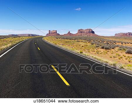 Picture - Remote desert road with mountain land formations.. Fotosearch