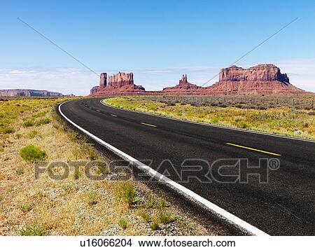 Picture - Road in scenic desert landscape with mesa and mountains.. Fotosearch