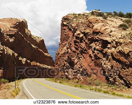 Rural road dug through large rock formation in Utah View Large Photo Image Stock Photograph - Rural road dug through large rock formation in Utah. Fotosearch