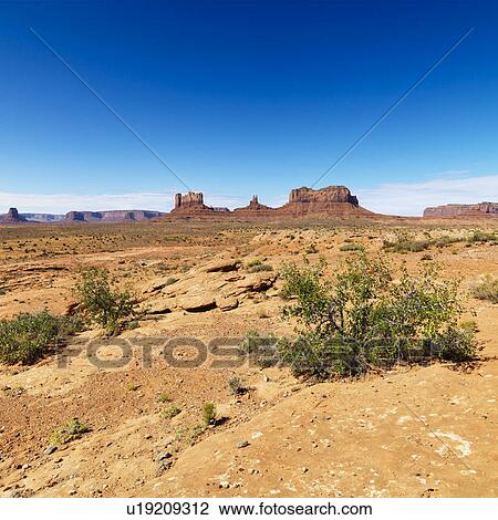 Stock Image - Scenic desert landscape with mountains and foliage. Fotosearch