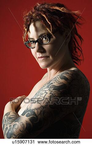 Stock Image - Side view portrait of adult woman with tattoos.. Fotosearch