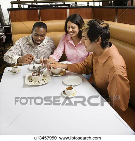 Small group of friends sharing dessert at a restaurant View Large Photo Image Stock Image - Small group of friends sharing dessert at a restaurant. Fotosearch