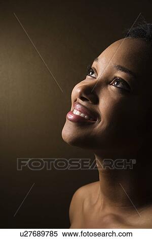Smiling African-American young adult female looking up. View Large Photo Image Stock Photography - Smiling African-American young adult female looking up.. Fotosearch