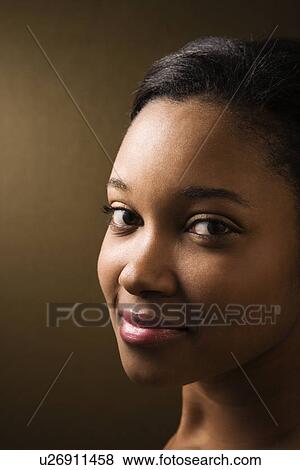 Stock Photo - Smiling young adult female looking at viewer. Fotosearch