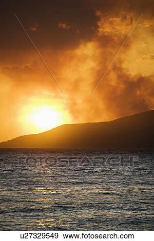 Sun setting over island with ocean View Large Photo Image Stock Photo - Sun setting over island with ocean. Fotosearch