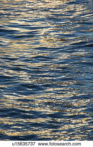 Sunlight reflecting on waves in water View Large Photo Image Stock Photo - Sunlight reflecting on waves in water. Fotosearch