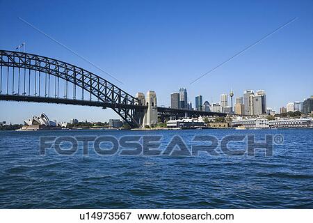 Stock Photo - Sydney Harbour Bridge with view of downtown skyline and Sydney Opera House in Australia. Fotosearch