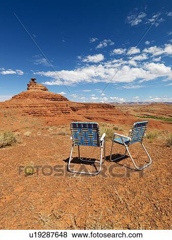 Stock Photo - Two outdoor lawn chairs in scenic desert landscape with mesa land formation.. Fotosearch