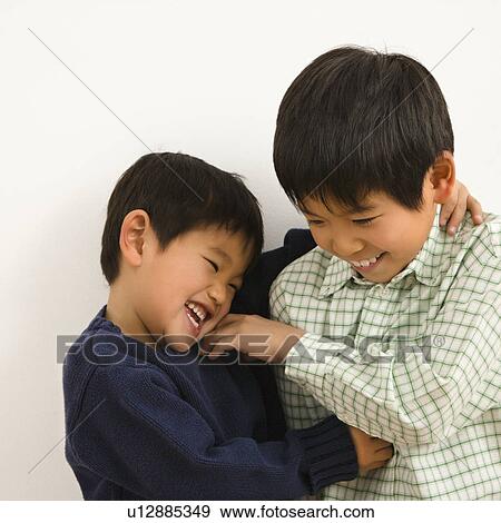 Stock Photo - Two young Asian brothers playing and laughing.. Fotosearch