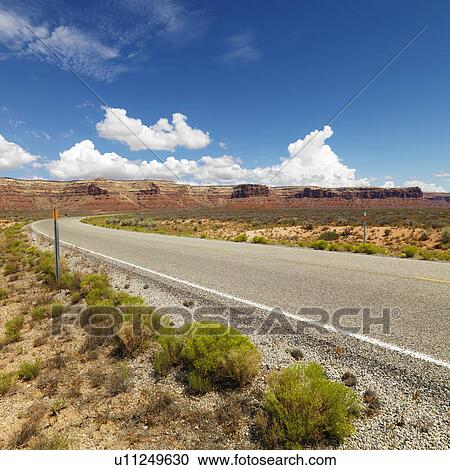 Stock Image - Utah landscape with distant mountains and two lane road.. Fotosearch