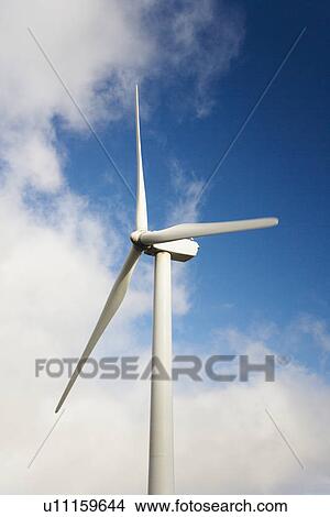 Wind turbine against blue sky and clouds View Large Photo Image Picture - Wind turbine against blue sky and clouds. Fotosearch