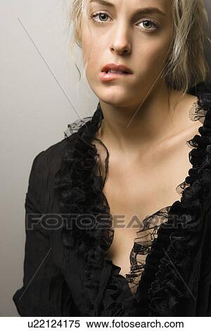 Stock Photography - Woman biting lip and looking at viewer. Fotosearch
