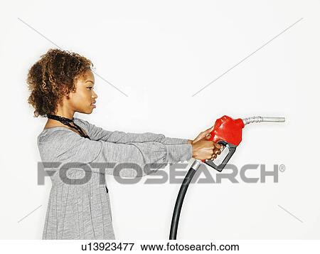 Woman holding gas pump nozzle like a gun View Large Photo Image Stock Photo - Woman holding gas pump nozzle like a gun. Fotosearch