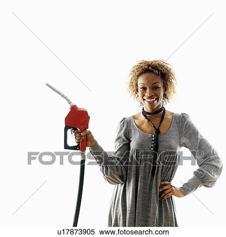 Stock Photography - Woman holding gasoline pump nozzle smiling. Fotosearch