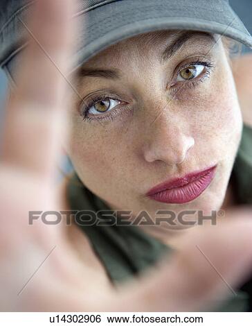Woman holding up hands and looking up at viewer View Large Photo Image Stock Photograph - Woman holding up hands and looking up at viewer. Fotosearch