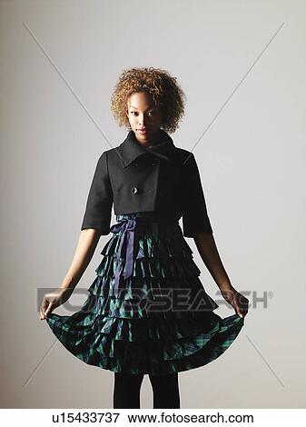 Woman in pretty ruffled dress holding the hem out to sides View Large Photo Image Stock Photo - Woman in pretty ruffled dress holding the hem out to sides. Fotosearch