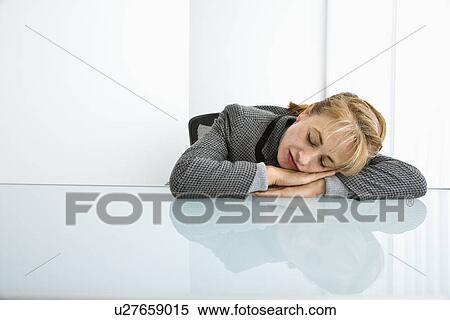Woman Sleeping On Desk With Head On Hands Stock Photography
