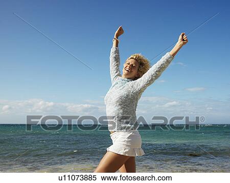 Woman smiling with arms raised in air on Maui, Hawaii beach. View Large Photo Image Stock Photography - Woman smiling with arms raised in air on Maui, Hawaii beach.. Fotosearch
