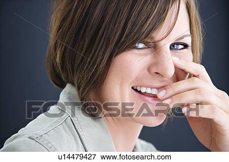 Woman smiling with hand to mouth View Large Photo Image Stock Photo - Woman smiling with hand to mouth. Fotosearch