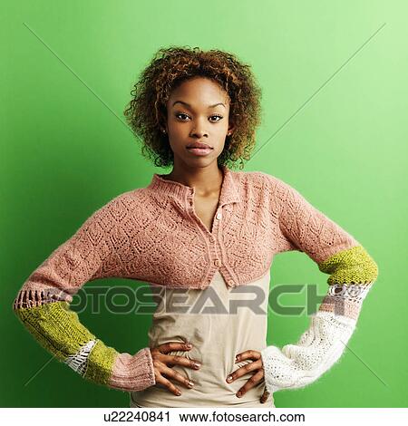 Woman standing against green background with hands on hips View Large Photo Image Stock Image - Woman standing against green background with hands on hips. Fotosearch