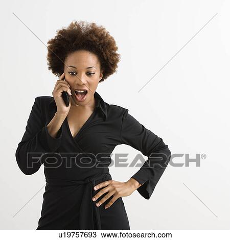 Woman talking on cellphone looking shocked against white background. View Large Photo Image Stock Image - Woman talking on cellphone looking shocked against white background.. Fotosearch
