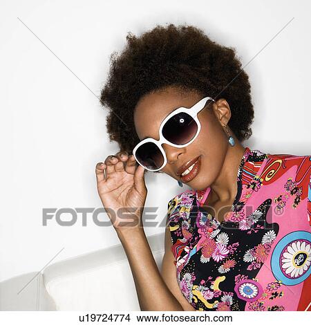 Woman with afro wearing vintage print fabric and oversized sunglasses View Large Photo Image Picture - Woman with afro wearing vintage print fabric and oversized sunglasses. Fotosearch