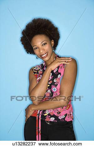 Stock Photo - Woman with afro wearing vintage print fabric smiling. Fotosearch