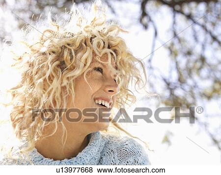 Woman with curly blonde hair smiling View Large Photo Image Stock Photo - Woman with curly blonde hair smiling . Fotosearch