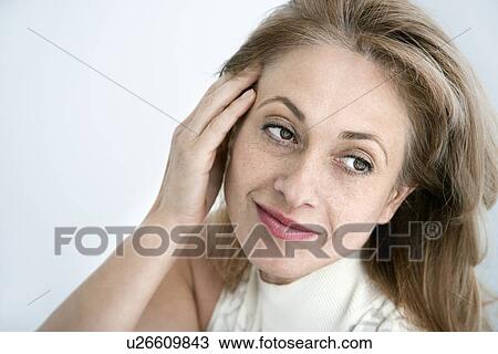 Woman with hand to head looking away View Large Photo Image Stock Image - Woman with hand to head looking away. Fotosearch