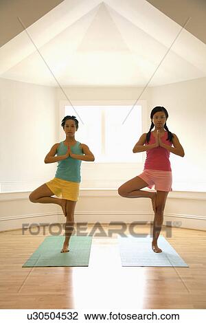 Women balancing doing yoga tree pose View Large Photo Image Stock Image - Women balancing doing yoga tree pose. Fotosearch
