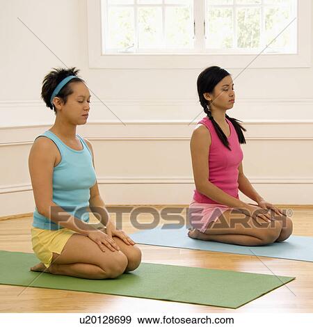 Women sitting on yoga mats with eyes closed View Large Photo Image Stock Photo - Women sitting on yoga mats with eyes closed. Fotosearch