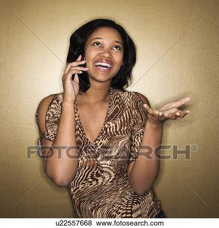 Young African-American young woman talking on cellphone smiling. View Large Photo Image Stock Photo - Young African-American young woman talking on cellphone smiling.. Fotosearch