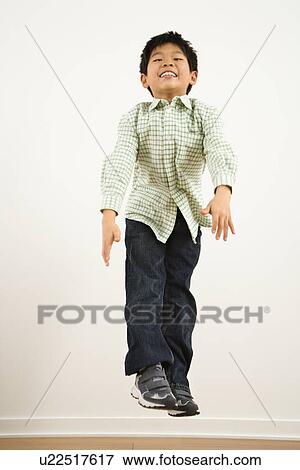 Young Asian boy jumping up into air smiling. View Large Photo Image Stock Photo - Young Asian boy jumping up into air smiling.. Fotosearch