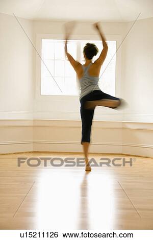 Young woman in motion jumping and dancing indoors by sunlit window. View Large Photo Image Stock Photograph - Young woman in motion jumping and dancing indoors by sunlit window.. Fotosearch