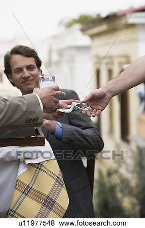 Businessmen at taverna paying bill View Large Photo Image Stock Photo - Businessmen at taverna paying bill. Fotosearch