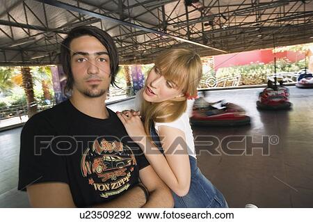 Stock Image - Teenage couple at game in amusement park. Fotosearch