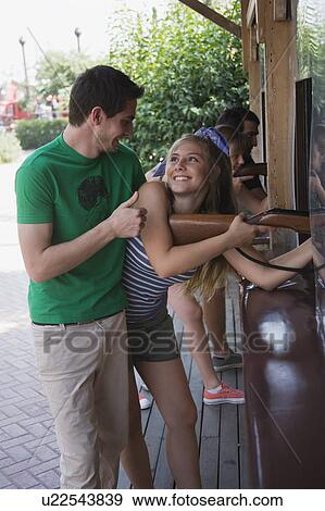 Teenage couple at game in amusement park View Large Photo Image Stock Photo - Teenage couple at game in amusement park. Fotosearch