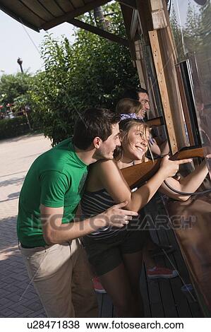 Teenage couple at game in amusement park View Large Photo Image Stock Photo - Teenage couple at game in amusement park. Fotosearch