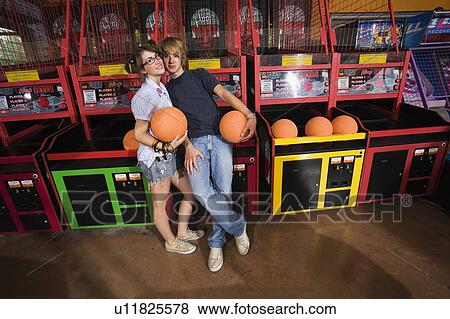 Stock Photo - Teenage couple at game in arcade. Fotosearch