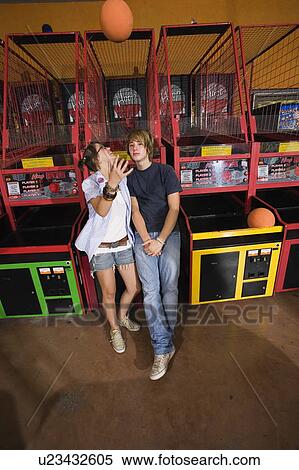 Teenage couple at game in arcade View Large Photo Image Stock Photography - Teenage couple at game in arcade. Fotosearch