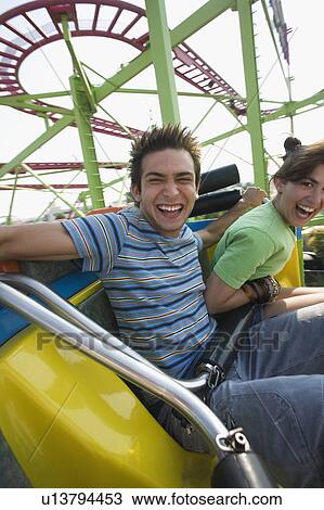 Teenage couple on amusement park ride View Large Photo Image Stock Image - Teenage couple on amusement park ride. Fotosearch