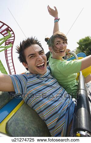 Stock Photography - Teenage couple on amusement park ride. Fotosearch