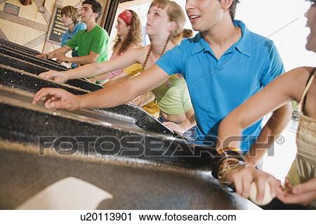 Teenagers playing game in amusement park View Large Photo Image Stock Image - Teenagers playing game in amusement park. Fotosearch