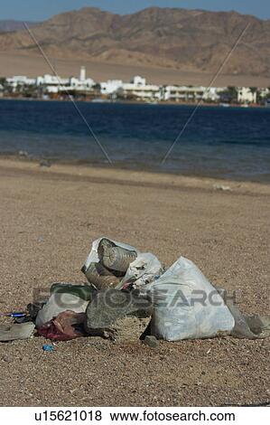 Stock Photo - Plastic and glass bottles just left on the beach after a night time party. Dahab. Egypt. Fotosearch