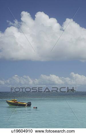 Stock Image - Small boat and blue sea, Rurutu, French Polynesia, Southern Pacific Ocean.. Fotosearch