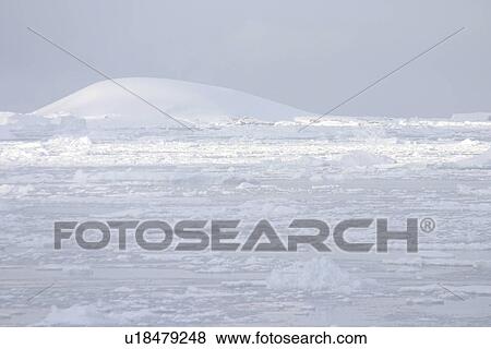 Stock Photo - View across snow fields, tabular icebergs Antarctica Peninsula. Fotosearch