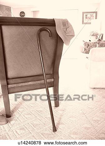 A cane leaning on the back of a chair View Large Photo Image Stock Photo - A cane leaning on the back of a chair. Fotosearch