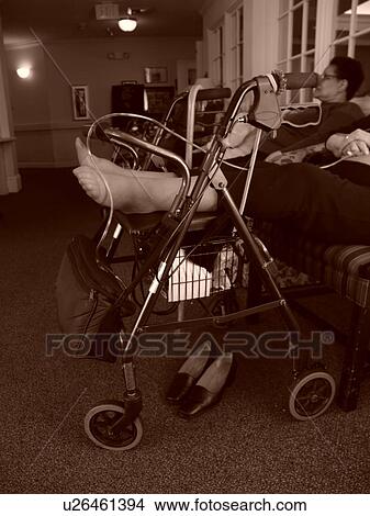 Picture - An elderly person rests their feet on a walker.. Fotosearch