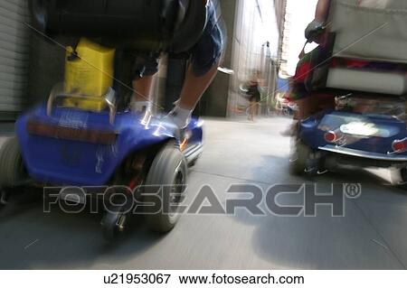 Back side of a scooter/cart being ridden down a busy street. View Large Photo Image Stock Photo - Back side of a scooter/cart being ridden down a busy street.. Fotosearch